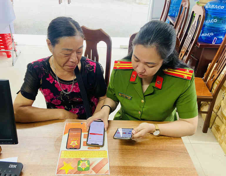 Cán bộ Công an huyện Tiên Yên hướng dẫn công dân sử dụng các tiện ích của VNeID. Ảnh: Ngọc Trâm