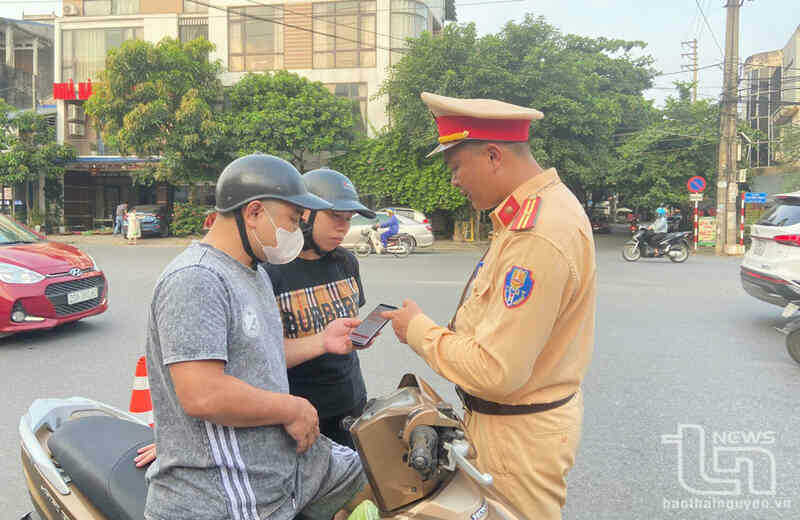 Cán bộ Cảnh sát giao thông kiểm tra thông tin giấy tờ được tích hợp trên ứng dụng VNeID.
